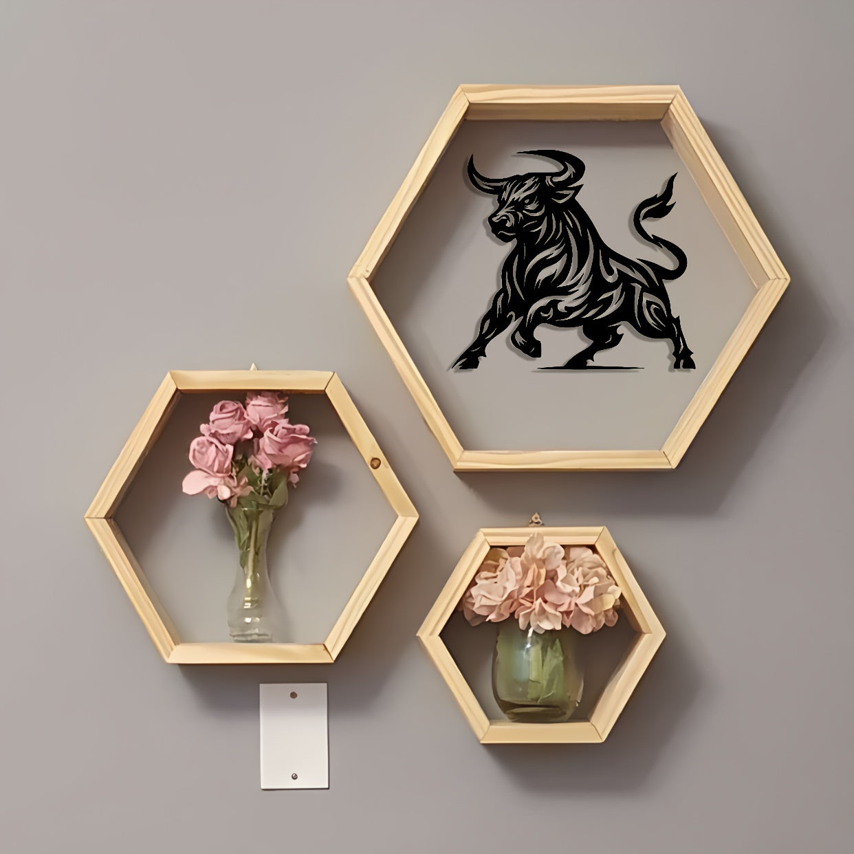 Abstract bull metal art in black displayed in wooden hexagonal shelf with pink flower vases, modern wall decor arrangement