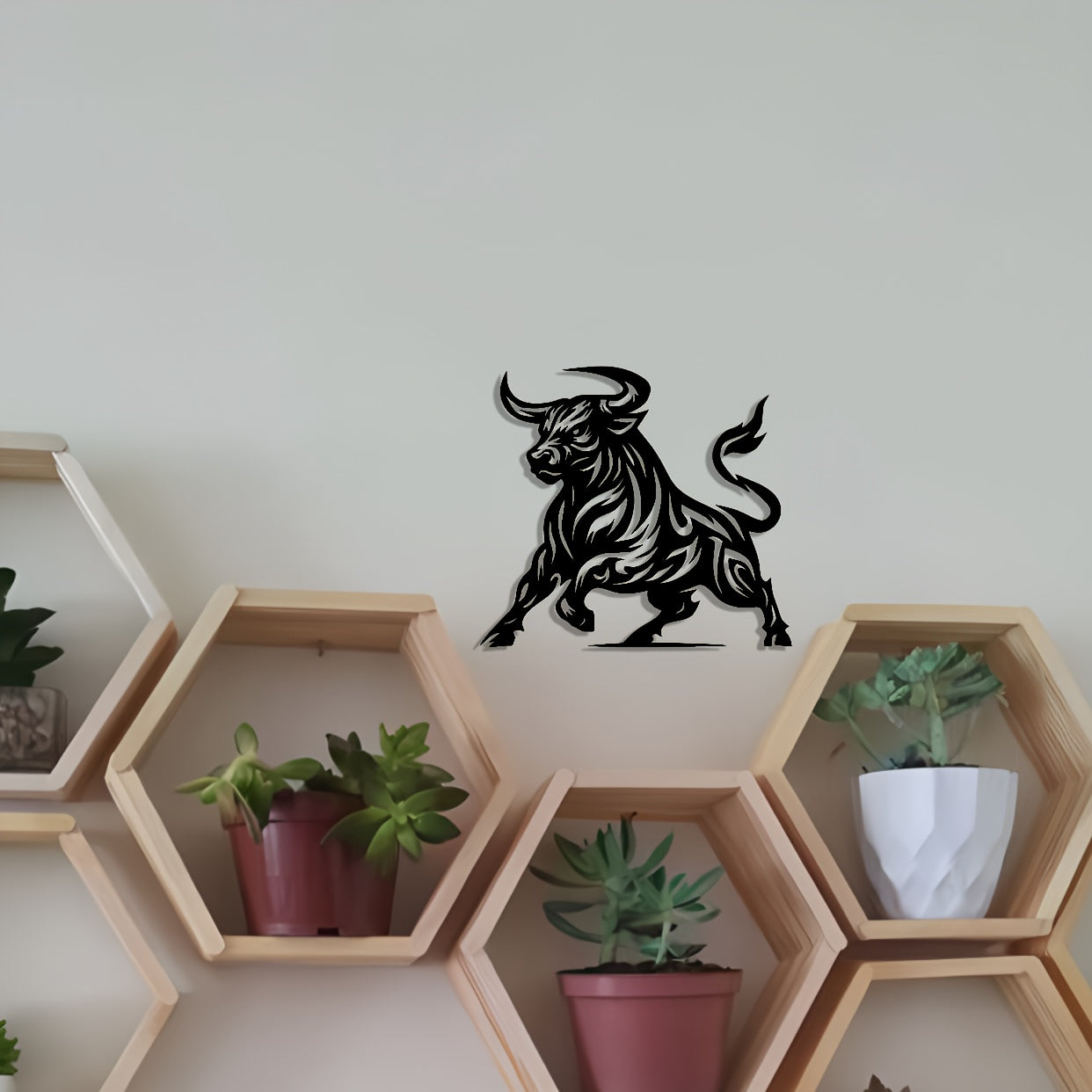 Modern abstract bull metal wall art with black silhouette mounted on white wall above hexagonal shelves with plants